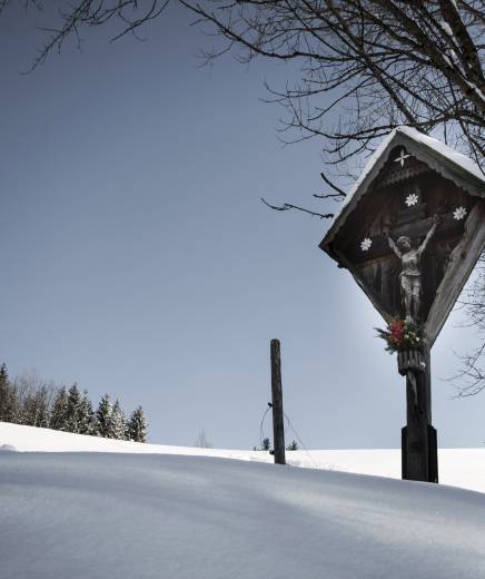 Marterl in verschneiter Winterlandschaft