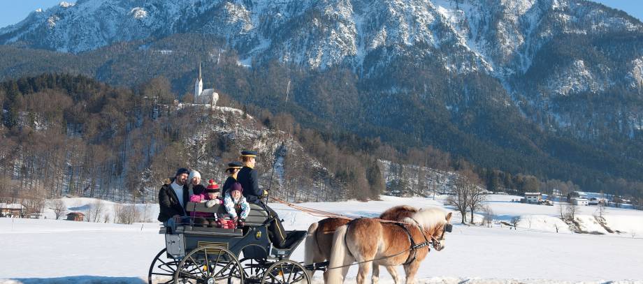 Pferdekutsche im Winter vor Alpenpanorama in Ebbs Tirol