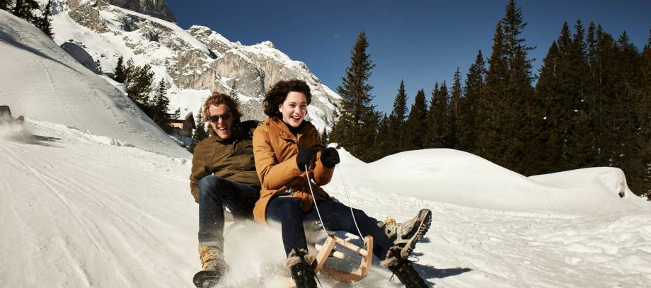 Paar beim Rodeln im Schnee